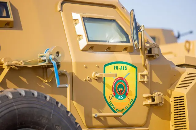 Un véhicule militaire jaune portant l'inscription 'FU-AES'
