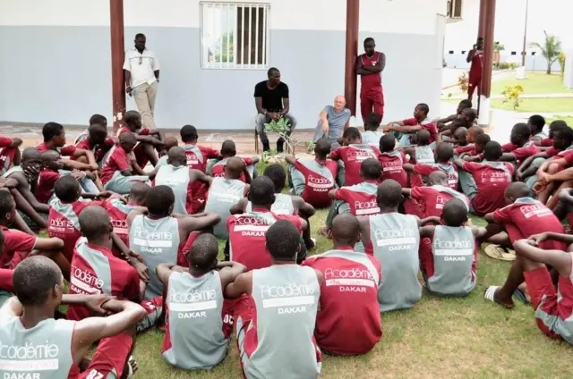 De jeunes joueurs âgés entre 12 et 14 ans écoutent attentivement les consignes de leurs entraîneurs.