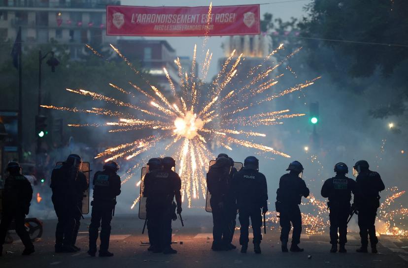 Des feux d'artifice éclatent devant les CRS, samedi soir à Paris.