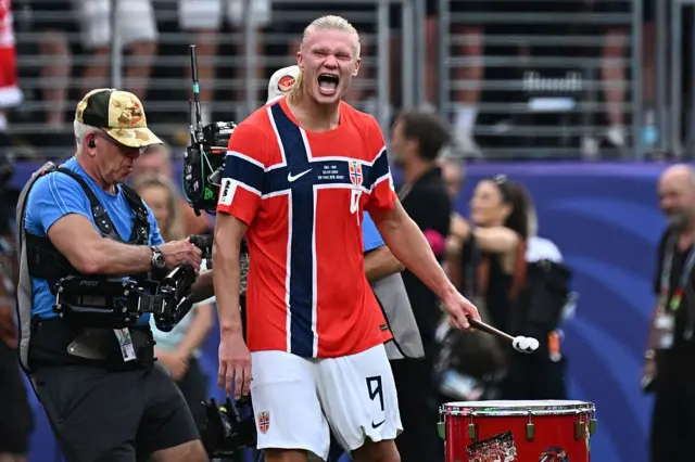 Erling Braut Haaland, attaquant norvégien, célébrant une victoire avec un tambour.