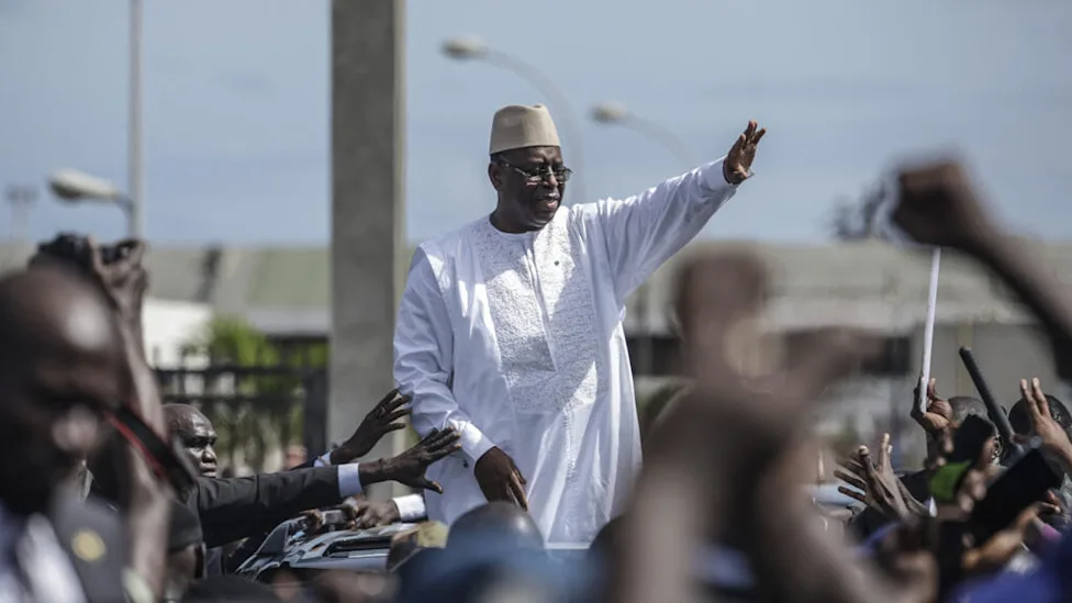 Macky Sall accompagné de dignitaires lors d'une cérémonie officielle au Sénégal