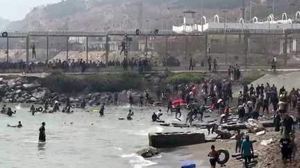 Des migrants arrivent sur la côte de l'enclave espagnole de Ceuta après avoir contourné à la nage la clôture frontalière entre le Maroc et l'Espagne, le 30 juillet 2026. (LUCIA DIAZ / AFP)