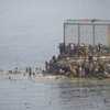 Des personnes contournent la digue de Tarajal afin d'entrer illégalement dans l'enclave espagnole de Ceuta depuis le Maroc, le 31&nbsp;juillet 2026. (MARCOS MORENO / ANADOLU / AFP)