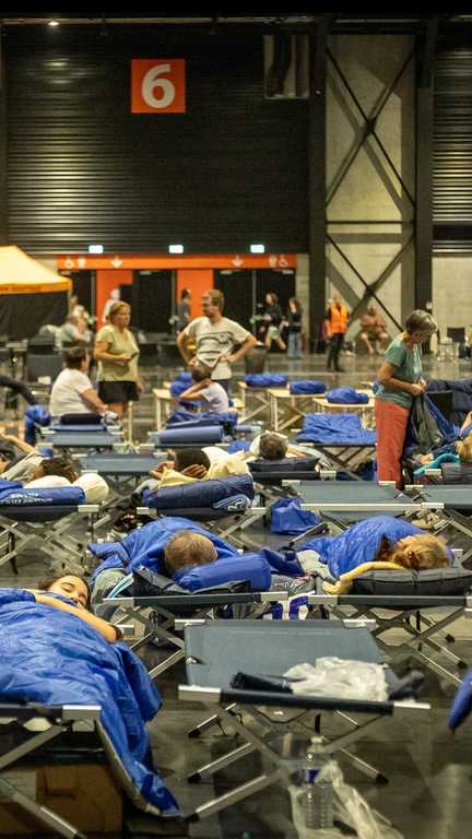 Des évacués de l'incendie de Saumos en Gironde dorment sur des lits de camp dans le parc des expositions de Bordeaux, en juillet 2026. (MAXPPP)